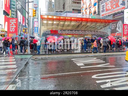 Gli ombrelli sono fuori sotto una leggera pioggia di settembre allo stand tkts a Times Square, crocevia del mondo. Foto Stock