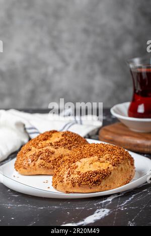 Pasta di sesamo e formaggio su fondo scuro. Cibo di strada turco. Peynirli pogaca Foto Stock