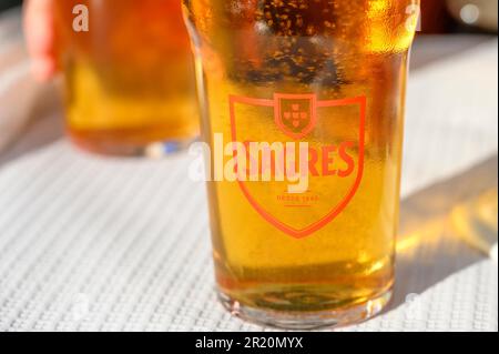 Lisbona, Portogallo - 30 aprile 2023: Un bicchiere di birra marca Sagres in un tavolo da ristorante patio. Foto Stock