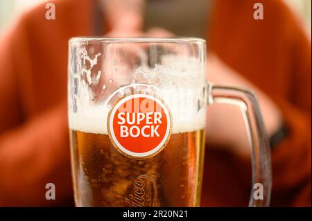 Lisbona, Portogallo - 30 aprile 2023: Un turista che gusta una birra Super Bock in un ristorante patio Foto Stock