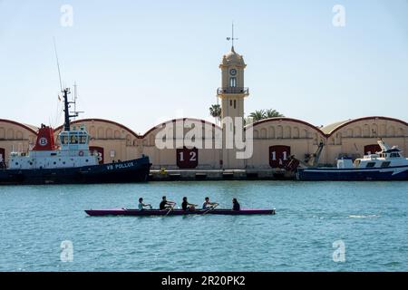 canoa nel porto con una barca da pesca sullo sfondo e gli edifici con i numeri 12 e 11 Foto Stock