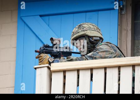 Hammelburg, Germania. 16th maggio, 2023. Un fantino montano assicura un edificio durante un esercizio militare presso la Scuola di Fanteria dell'Esercito tedesco di Hammelburg. Credit: Daniel Löb/dpa/Alamy Live News Foto Stock