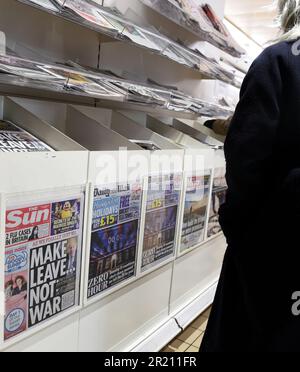 Fotografia di una donna che guarda i vari giornali britannici che riportano la Brexit. Il giornale Sun riporta anche i primi due casi confermati di Covid-19 in Gran Bretagna. Foto Stock