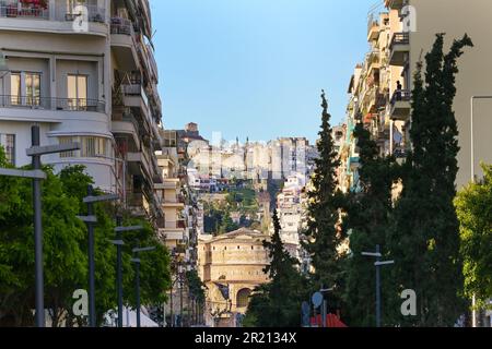 Vista attraverso una strada principale di Salonicco, la Grecia, l'antica Rotunda e la fortezza nella storica città alta, il turismo e la destinazione di viaggio Foto Stock