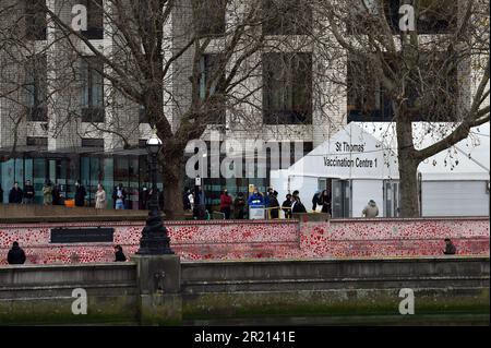 Centinaia di persone fanno la coda per il loro richiamo jab fuori Guy's e St Thomas's Hospital a Londra in mezzo alla pandemia di coronavirus COVID-19. Dicembre 2021. Foto Stock