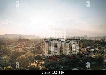 Una vista aerea di un vasto paesaggio urbano caratterizzato dagli alti edifici di uno skyline, adagiato sullo sfondo di colline ondulate Foto Stock