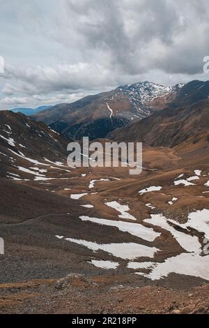 Proiezione verticale di una vista pittoresca di una valle innevata tra le pendici dei Pirenei in una nuvolosa giornata autunnale. Il concetto di aspro montagna Foto Stock