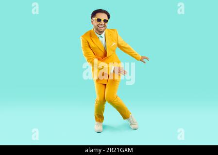 Felice giovane uomo eccitato ballare sullo sfondo studio Foto Stock