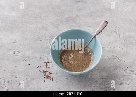 Cottura uovo di semi di lino vegano su sfondo grigio testurizzato, vista dall'alto Foto Stock