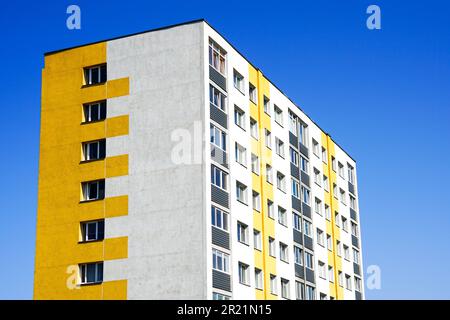 Edificio di appartamenti a più piani ristrutturato e isolato facciata frammento su uno sfondo blu cielo Foto Stock