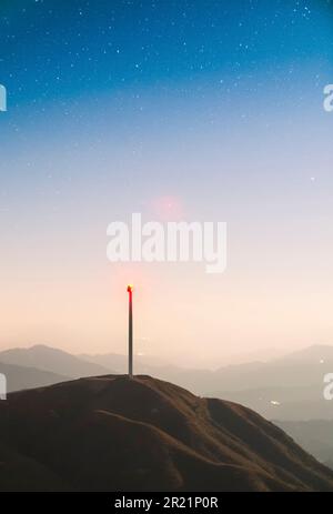 Una maestosa turbina eolica illuminata dalla luce soffusa della luna argentata Foto Stock