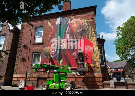 Liverpool, Regno Unito. 16th maggio, 2023. L'artista Paul Curtis aggiunge un tocco finale a una nuova arte murale del Liverpool FC Women's player Missy Bo Kearns a Tancred Road, Liverpool. Uno scuser e lifelong Red, Kearns è stato sui libri del randello dall'età di otto anni ed ha progredito con successo attraverso le fila con Liverpool mentre inoltre è capped dall'Inghilterra al livello U23. Credit: SOPA Images Limited/Alamy Live News Foto Stock