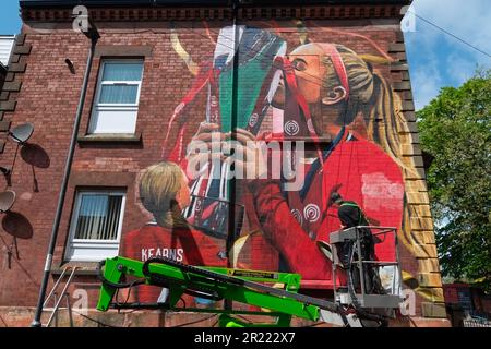 Liverpool, Regno Unito. 16th maggio, 2023. L'artista Paul Curtis aggiunge un tocco finale a una nuova arte murale del Liverpool FC Women's player Missy Bo Kearns a Tancred Road, Liverpool. Uno scuser e lifelong Red, Kearns è stato sui libri del randello dall'età di otto anni ed ha progredito con successo attraverso le fila con Liverpool mentre inoltre è capped dall'Inghilterra al livello U23. Credit: SOPA Images Limited/Alamy Live News Foto Stock