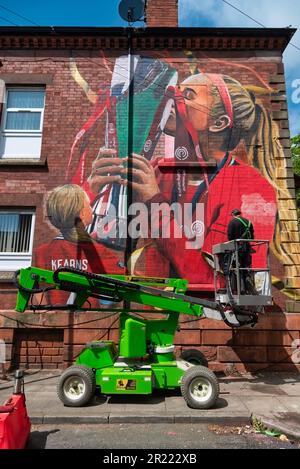 Liverpool, Regno Unito. 16th maggio, 2023. L'artista Paul Curtis aggiunge un tocco finale a una nuova arte murale del Liverpool FC Women's player Missy Bo Kearns a Tancred Road, Liverpool. Uno scuser e lifelong Red, Kearns è stato sui libri del randello dall'età di otto anni ed ha progredito con successo attraverso le fila con Liverpool mentre inoltre è capped dall'Inghilterra al livello U23. Credit: SOPA Images Limited/Alamy Live News Foto Stock