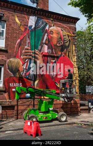 Liverpool, Regno Unito. 16th maggio, 2023. L'artista Paul Curtis aggiunge un tocco finale a una nuova arte murale del Liverpool FC Women's player Missy Bo Kearns a Tancred Road, Liverpool. Uno scuser e lifelong Red, Kearns è stato sui libri del randello dall'età di otto anni ed ha progredito con successo attraverso le fila con Liverpool mentre inoltre è capped dall'Inghilterra al livello U23. Credit: SOPA Images Limited/Alamy Live News Foto Stock