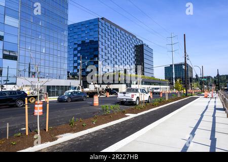 BELLEVUE, WA, USA – 3 MAGGIO 2023: Spring District, nuova costruzione di edifici di uffici in vetro con personale stradale che lavora su strada e mediana Foto Stock