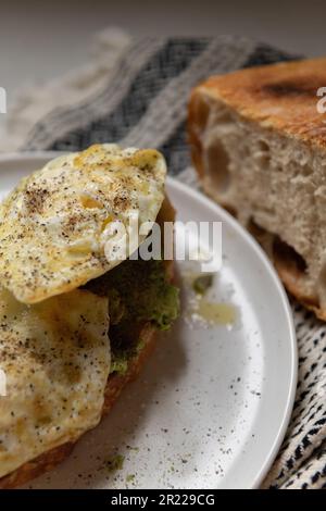 Toast all'uovo all'avocado con un bel pane artigianale Foto Stock