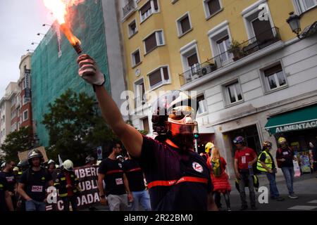 Madrid, Spagna. 16th maggio, 2023. Durante la dimostrazione, un protester tiene la fiamma del fumo. I vigili del fuoco si sono manifestati per protestare nelle strade di Madrid contro le condizioni di lavoro imposte loro dal governo spagnolo. Credit: SOPA Images Limited/Alamy Live News Foto Stock