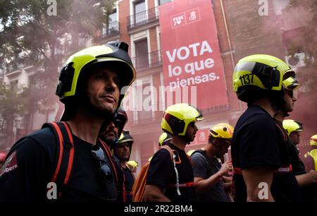 Madrid, Spagna. 16th maggio, 2023. Durante la manifestazione, i manifestanti hanno visto indossare un casco regolamentare davanti alla sede del Partito Socialista dei lavoratori Spagnoli. I vigili del fuoco si sono manifestati per protestare nelle strade di Madrid contro le condizioni di lavoro imposte loro dal governo spagnolo. Credit: SOPA Images Limited/Alamy Live News Foto Stock