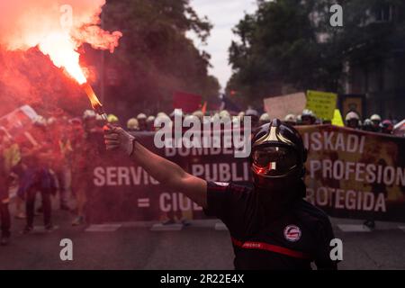 Madrid, Spagna. 16th maggio, 2023. Durante la dimostrazione, un vigile del fuoco tiene un bagliore di fumo rosso. Dimostrazione dei vigili del fuoco spagnoli organizzata dalla Professional Firefighters Union (CUBP). I vigili del fuoco hanno annunciato che chiederanno l'approvazione di una legge quadro che distingua le loro funzioni e poteri, poiché hanno assicurato che attualmente ci sono molte comunità autonome che non hanno leggi che regolano la loro attività, lasciandole non protette. Credit: SOPA Images Limited/Alamy Live News Foto Stock