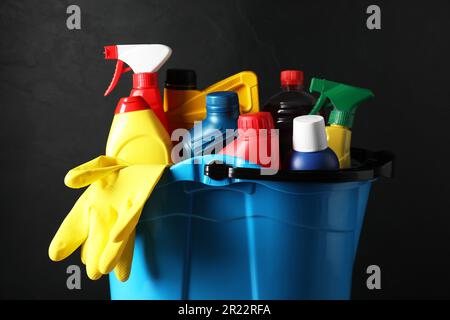 Secchio azzurro con prodotti per la pulizia dell'auto su sfondo nero Foto Stock