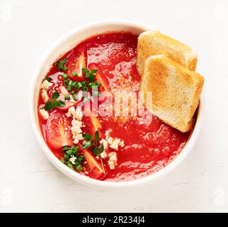 Zuppa di pomodoro su tavolo bianco, vista dall'alto. Foto Stock