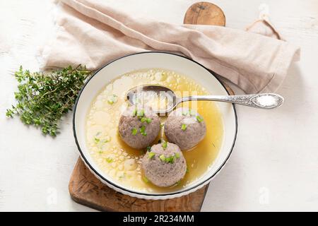 Canederli o Knodel in brodo con cipolla verde, pasta tipica o gnocchi per le Alpi, Alto Adige, cucina tedesca, italiana, austriaca. In bre obsoleto Foto Stock