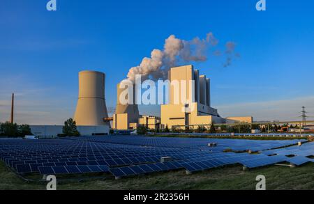 Lippendorf, Germania. 16th maggio, 2023. Il sole della sera splende sulle torri di raffreddamento della centrale di Lippendorf dietro un parco solare. La centrale elettrica brucia la lignite dalle miniere di opencast circostanti per generare elettricità e calore. L'eliminazione graduale della lignite metterà fine alla produzione di energia a carbone al più tardi nel 2035. Credit: Jan Woitas/dpa/Alamy Live News Foto Stock