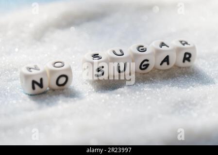 nessun blocco di testo dello zucchero con lo zucchero bianco sullo sfondo di legno, suggerendo dieta e mangiare meno zucchero per concetto di salute Foto Stock