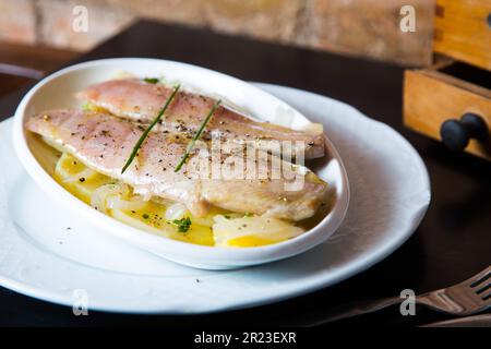 Filetti di sgombro marinati su patate al forno. Foto Stock