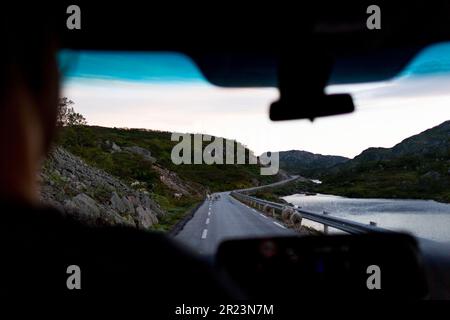 Una vista panoramica di una strada tortuosa attraverso le montagne catturate dall'interno di un veicolo. Foto Stock