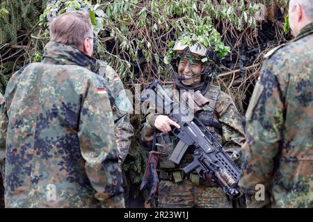 Hammelburg, Germania. 16th maggio, 2023. Una soldato femminile sorride al ministro (l) durante l'esercizio militare per la visita inaugurale del ministro della Difesa tedesco Boris Pistorius alla scuola di fanteria di Hammelburg. Credit: Daniel Löb/dpa/Alamy Live News Foto Stock