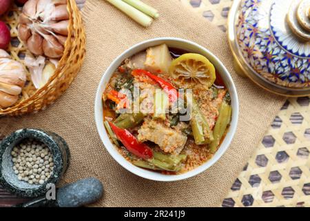 Curry rosso tailandese con gloria mattutina e pancia di maiale - autentico cibo tailandese chiamato Kang Tay po servito in porcellana Benjarong Foto Stock