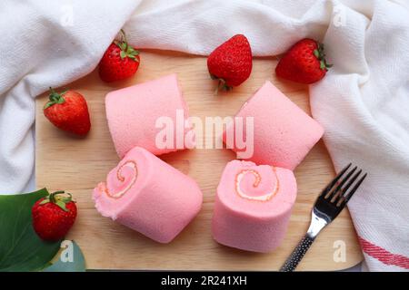 Torta di fragole rosa con crema servita su vassoio di legno con vista dall'alto Foto Stock