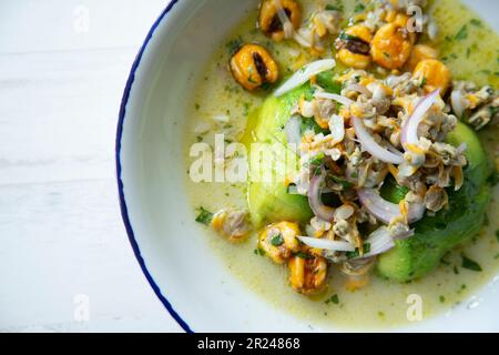 Cockle ceviche con avocado e mais tostato. Foto Stock