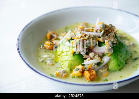 Cockle ceviche con avocado e mais tostato. Foto Stock