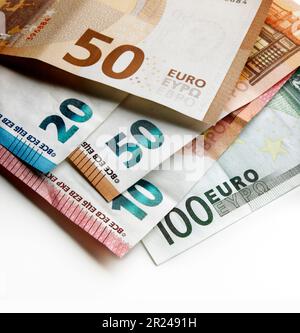 Vista ravvicinata. Messa a fuoco superficiale contro un mucchio di banconote in euro usate valori diversi con un effetto luce spot Foto Stock