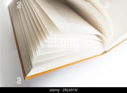 Vista primo piano defocalizzazione libro aperto. Messa a fuoco leggera sulle pagine di sinistra e spazio di copia di sfondo a destra. Foto Stock