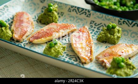 Piatto di triglie rosse di alta qualità cucinate al forno con verdure in un ristorante spagnolo. Foto Stock