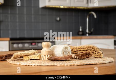 Bordo composto da varie spazzole e spugne di vari materiali naturali in cucina casalinga. Cocco, sisal, bambù, fibre di legno, spugna di mare. Foto Stock