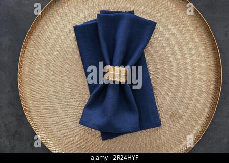 Vassoio con tovaglioli blu e anello decorativo su tavolo grigio, vista dall'alto Foto Stock