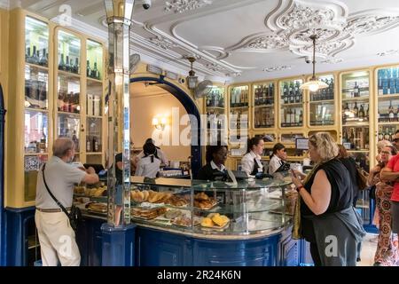 Lisbona, Portogallo-Ottobre 2022: Vista interna della pasticceria Pastéis de Belem con i clienti al banco per acquistare il famoso pastello de belem Foto Stock