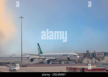 DUBAI, Emirati Arabi Uniti - CIRCA 2022: L'aereo Mahan Air collegato al ponte aereo dell'aeroporto internazionale di Dubai per salire a bordo dei passeggeri. Foto Stock