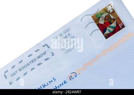 Francobollo natalizio di prima classe incollato sulla busta bianca 2022 con messaggio Get Boosted Now timbrato - francobollo di prima classe Foto Stock
