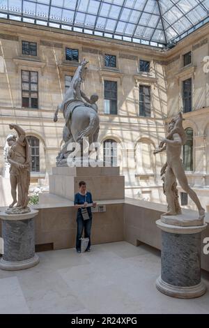 Parigi, Francia - 05 13 2023: Museo del Louvre. Una donna disegna la scultura nella Cour Marly Foto Stock