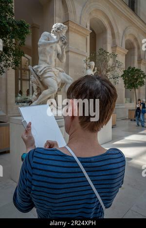 Parigi, Francia - 05 13 2023: Museo del Louvre. Una donna disegna la scultura nella Cour Marly Foto Stock