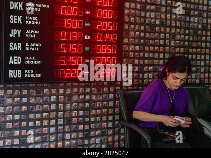 Istanbul, T¨¹rkiye. 15th maggio, 2023. Una donna conta banconote in un ufficio di cambio a Istanbul, T¨¹rkiye, 15 maggio 2023. La lira turca ha raggiunto un record minimo di 19,70 contro il dollaro degli Stati Uniti il martedì, mentre le elezioni presidenziali si stanno dirigendo verso un ballottaggio il 28 maggio dopo il voto inconcludente di domenica. Nel mercato aperto, il tasso di cambio è andato alto quanto 22 lire per dollaro il lunedì prima di cadere di nuovo a 20,25 il martedì. Credit: Omer Kuscu/Xinhua/Alamy Live News Foto Stock