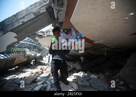 Un ragazzo palestinese che tiene un taglio di carta strappato del suo. I bambini palestinesi partecipano ad attività volte a sostenere la loro salute mentale vicino al sito di uno sciopero aereo israeliano a Deir al-Balah nella striscia centrale di Gaza. Questo è il seguito dei recenti combattimenti tra il gruppo militante della Jihad islamica e Israele a Gaza. Palestina. Foto Stock