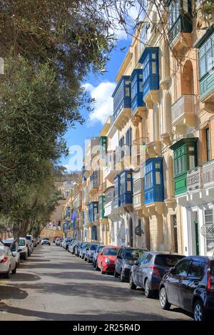 La foto è stata scattata sull'isola di Malta nel mese di gennaio. L'immagine mostra la strada della città di la Valletta con i balconi luminosi di hous Foto Stock