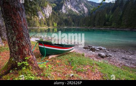 Piccola barca sulle rive del tranquillo Lago Tovel nel Nord Italia. Dolemites, Alpi italiane. Viaggi in Europa. Foto Stock